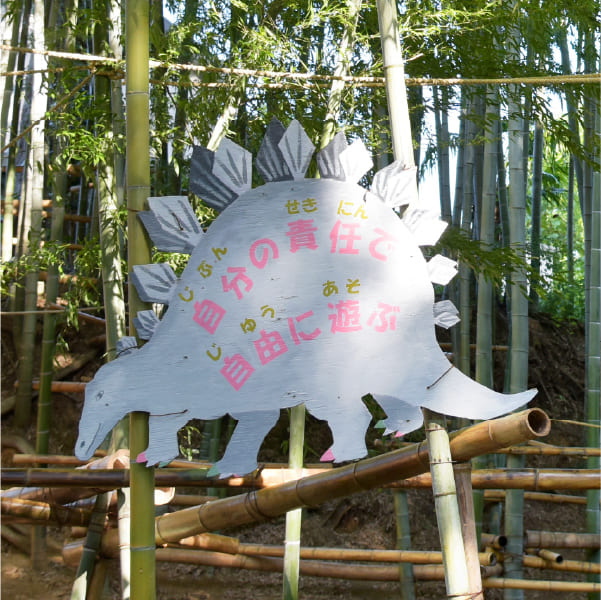 「自分の責任で自由に遊ぶ」と書かれた恐竜型の看板