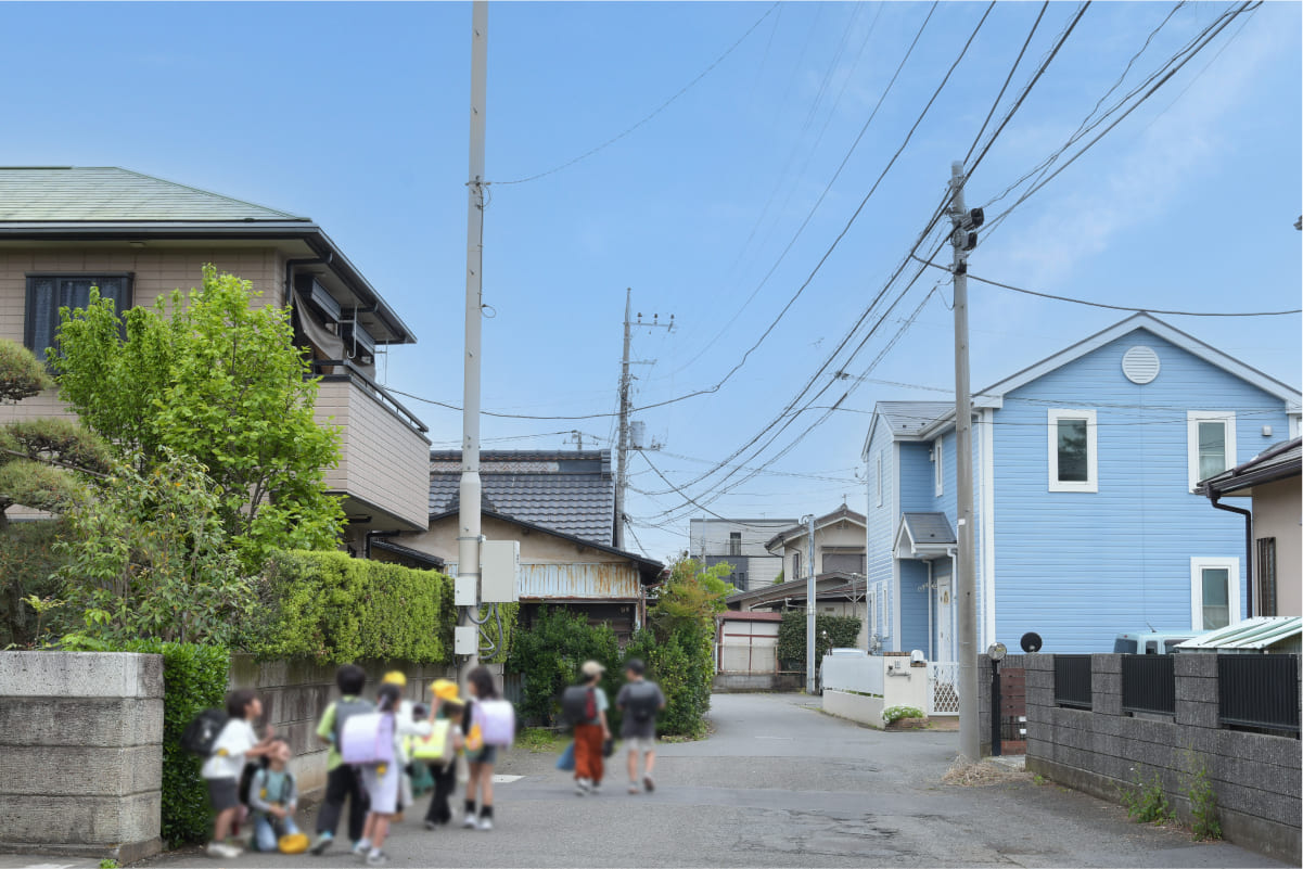 細い路地を歩く下校中の小学生達